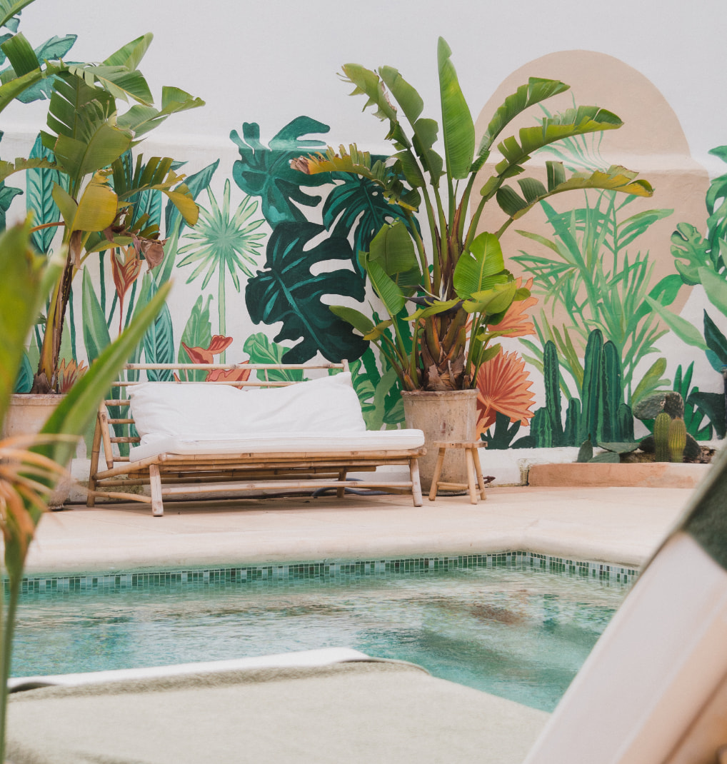 Poolside seating and a tropical wall mural