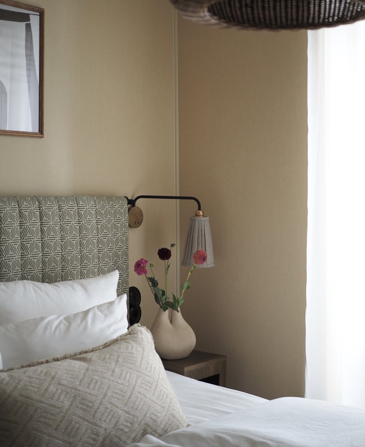 Bedroom with a wall lamp and soft natural light