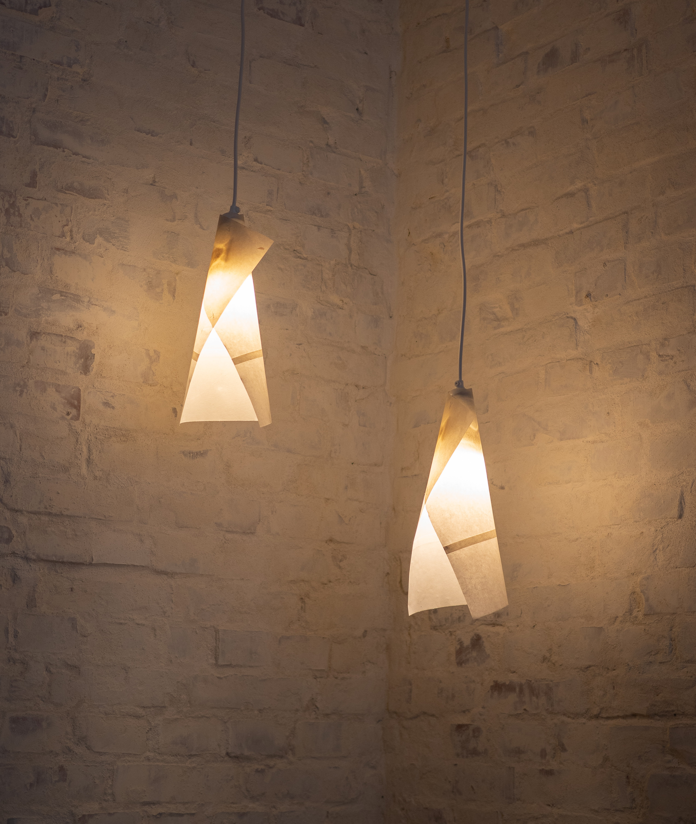 Two illuminated sculptural pendant lamps