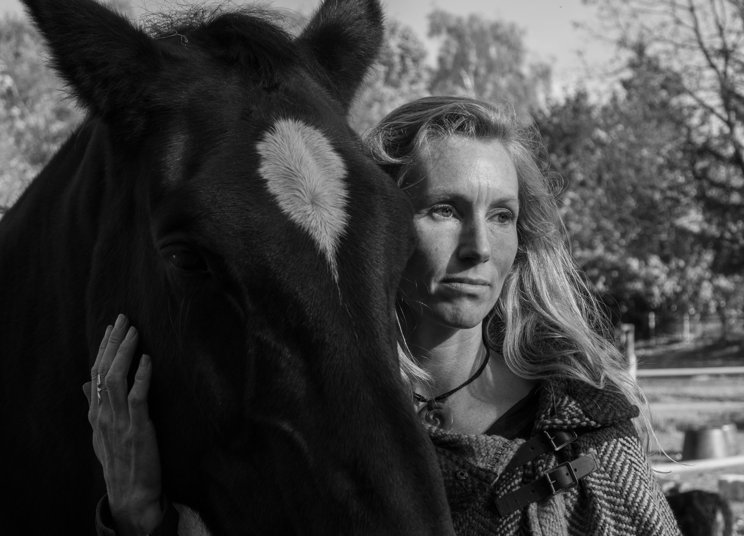 Close-up black-and-white portrait of Eva Krom with a horse