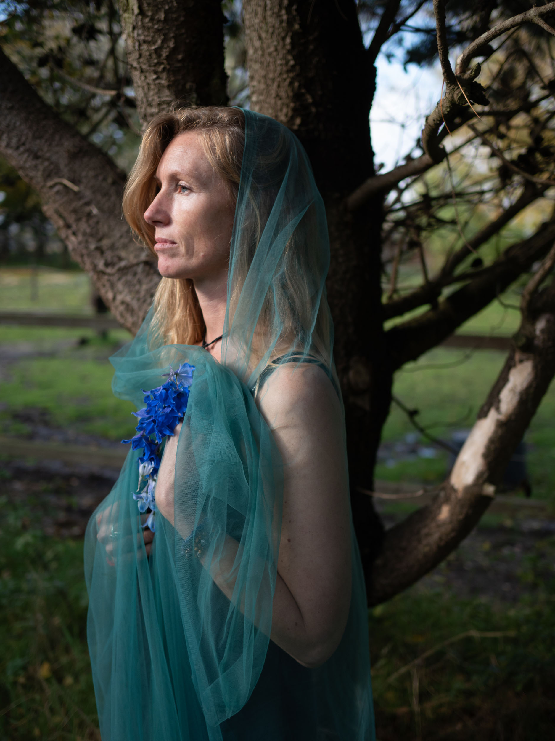 Eva Krom in a green wrap beneath a tree