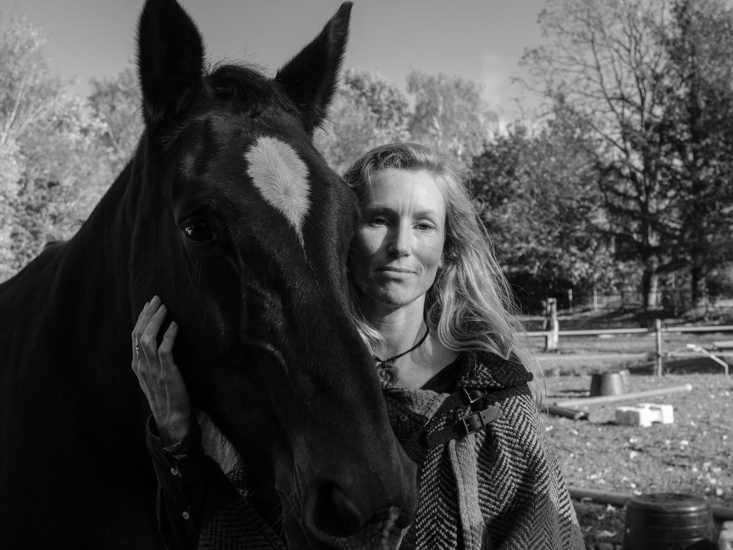 Black-and-white portrait of Eva Krom beside a horse