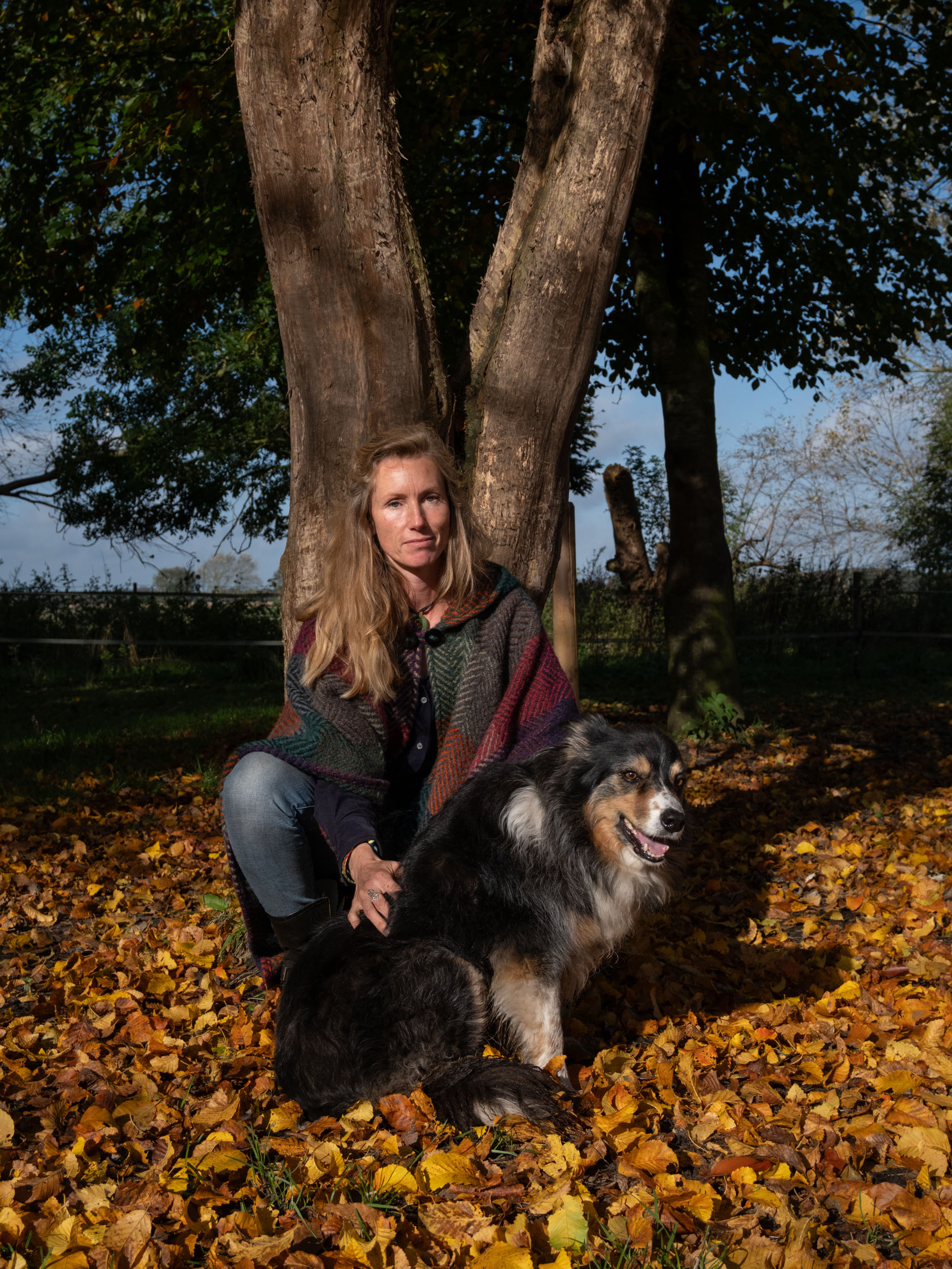 Eva Krom sitting among fallen leaves