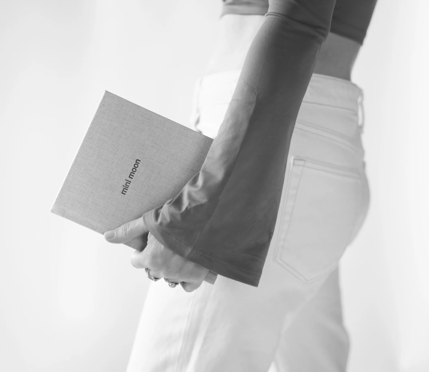 Black-and-white photograph of a person holding a book