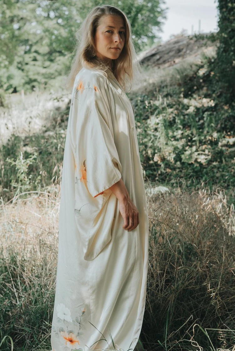 Woman in a light dress among tall grasses