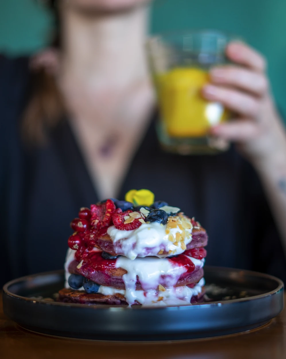 Plated dessert with edible flowers beside a matcha drink